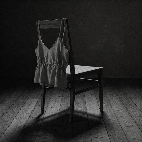 Empty wooden chair with camisole draped across the back – symbol of surrender and ritual undressing
